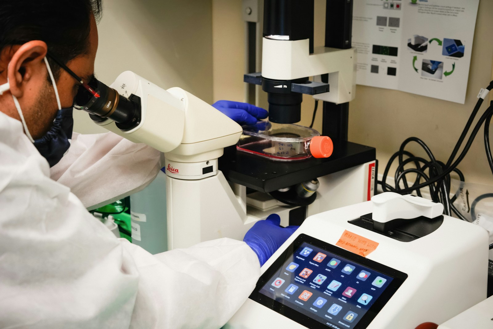 Illustrative photograph of medical researcher using microscope.